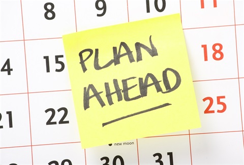 A calendar page with a reminder to 'Plan Ahead' on a bright yellow note.