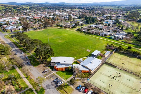 Image of an oval, building and tennis courts from above