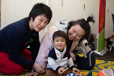 Two adults and a child smile at the camera.