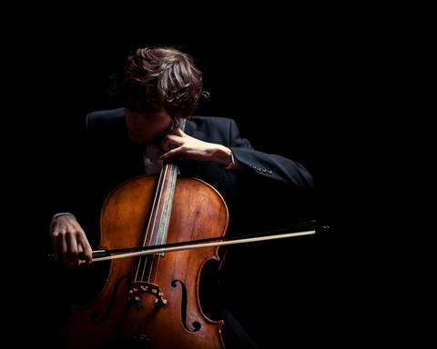 Focused concentration as the cellist draws sound from the instrument.