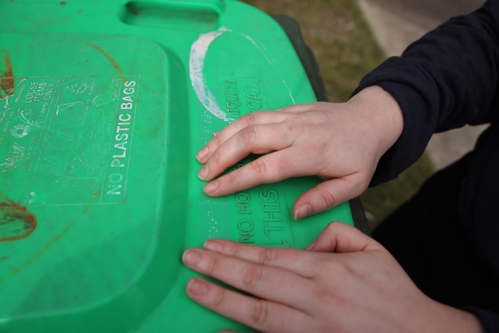 A person using braille bin stickers